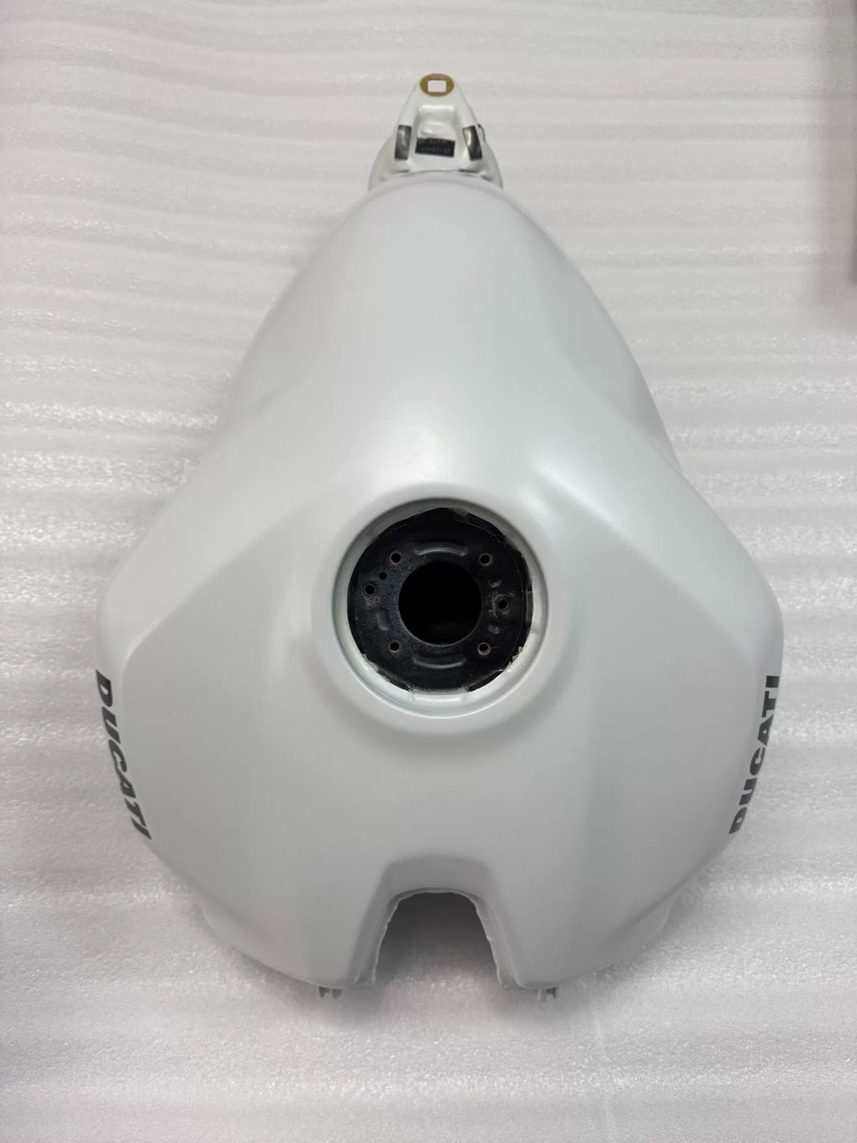 White fuel tank for Ducati Panigale V2, front three-quarter view showing smooth gloss finish and mounting points