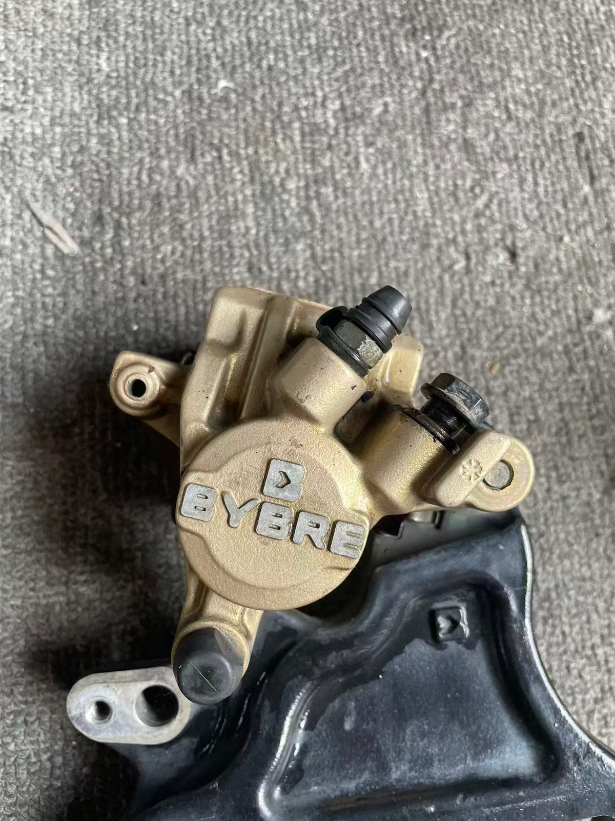 BMW G 310 R brake caliper side angle view displaying caliper body and fluid port detail