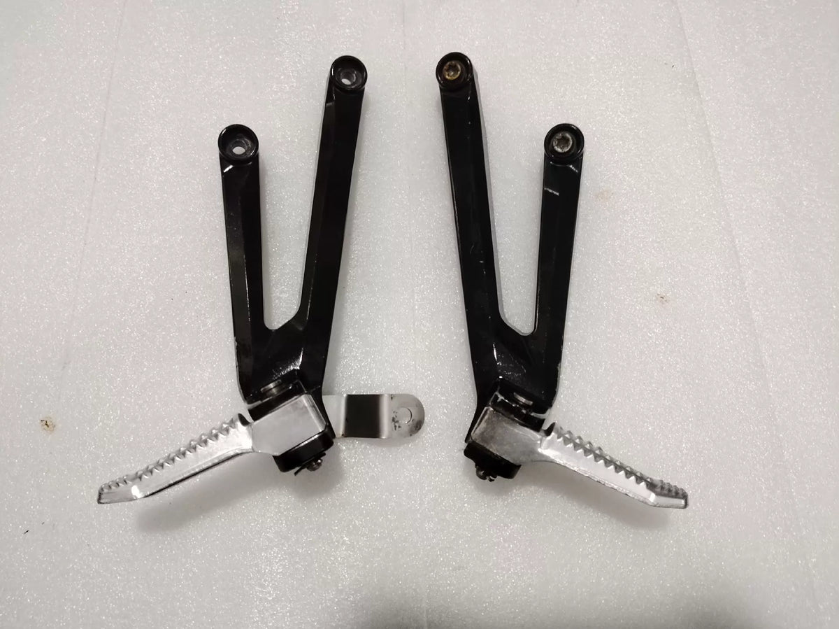 BMW S1000RR footpeg bracket, front angle view showing mounting points and machined aluminum construction