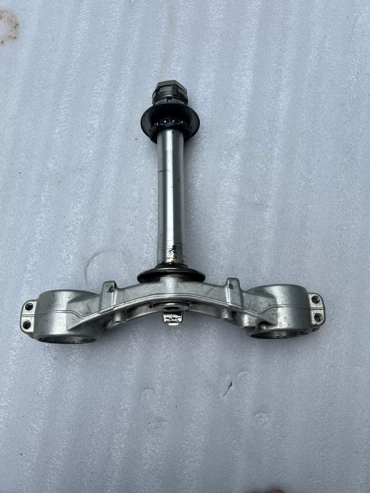 BMW S1000RR triple clamp front view showing upper and lower yoke assembly with stem and fork clamp holes