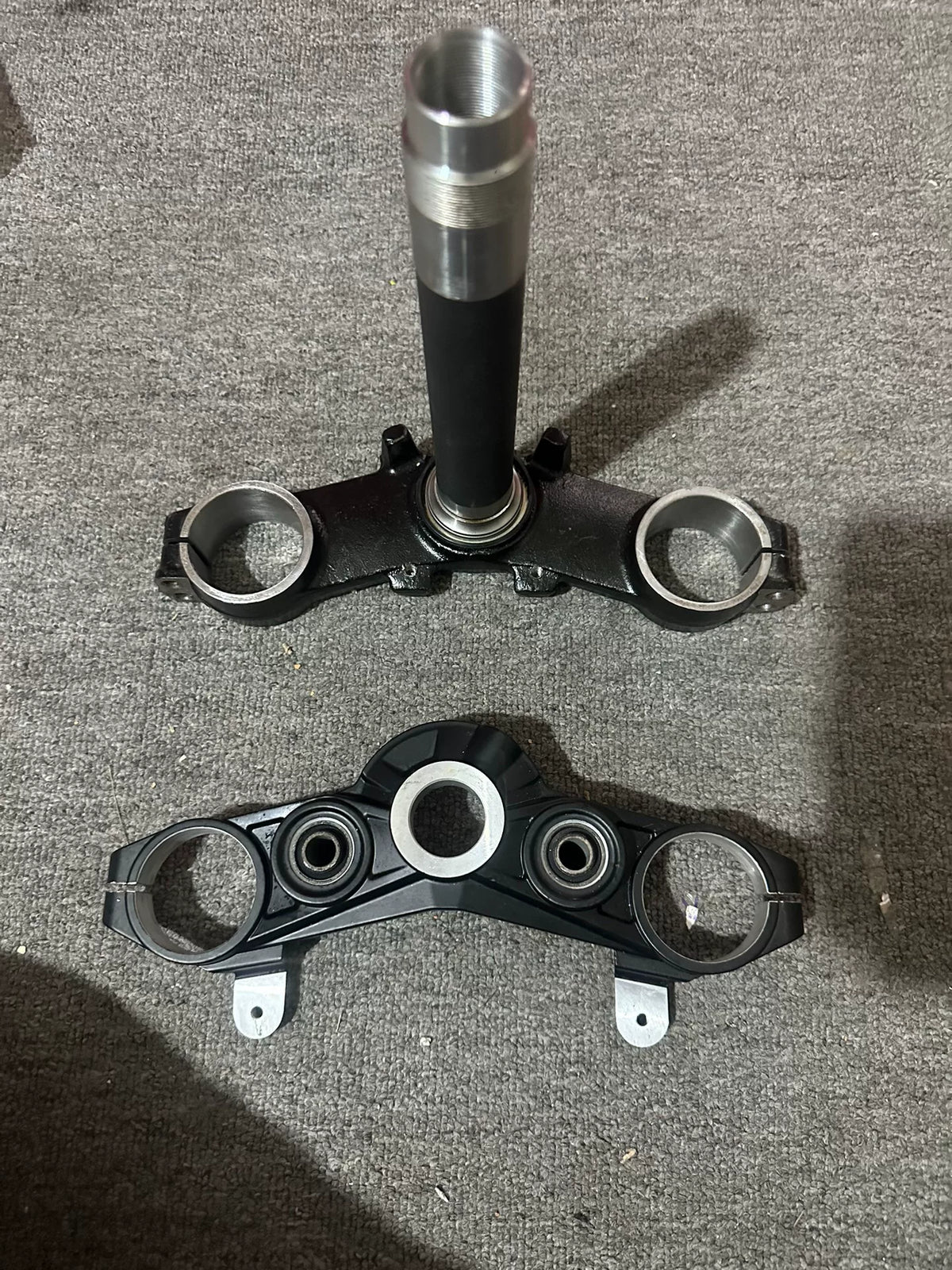 Kawasaki Z900 triple clamp front view showing machined aluminum upper and lower clamps with stem