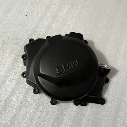 BMW F900R stator cover shown from front angle, black finish, bolt holes visible, clean condition