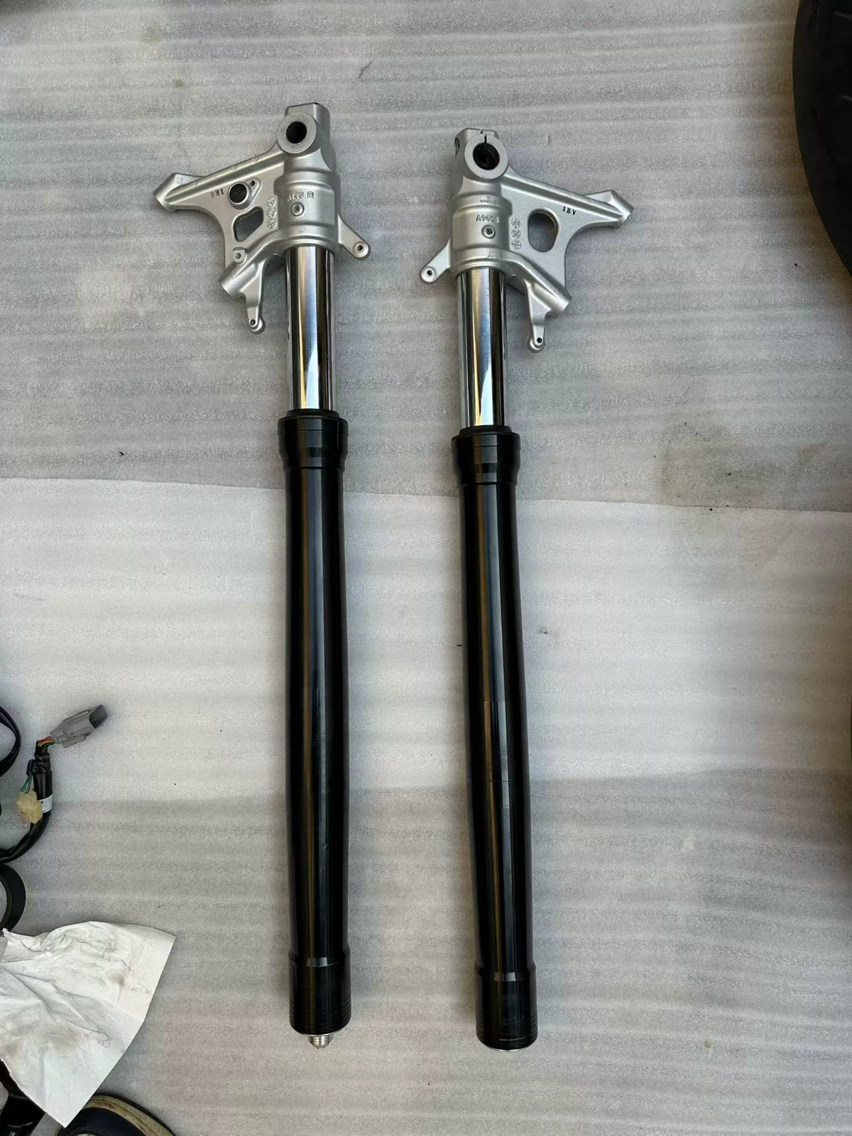 Aprilia Tuono 660 front fork rods pair, straight chrome steel shafts shown side by side, full length view