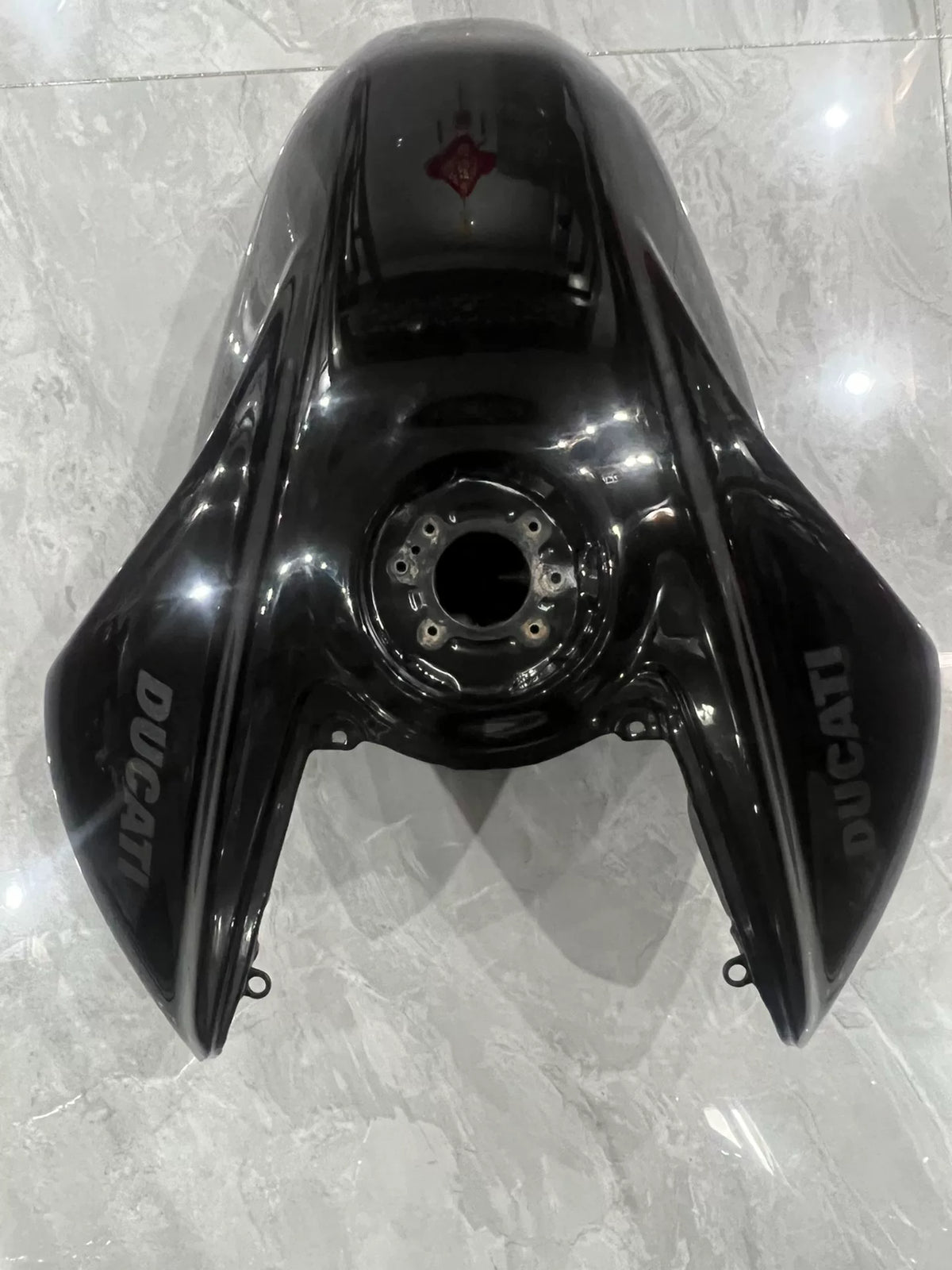 Ducati Diavel V4 black gas tank front angle view showing sleek contoured body and filler cap