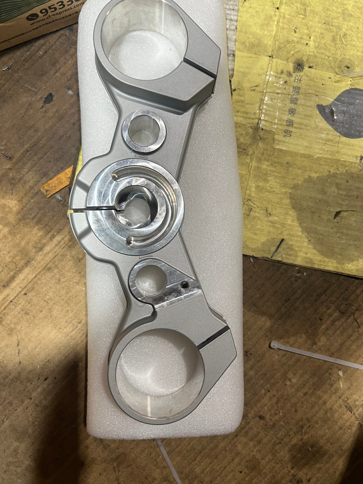 BMW F800GS triple clamp top-down view displaying machined aluminum construction and bolt holes
