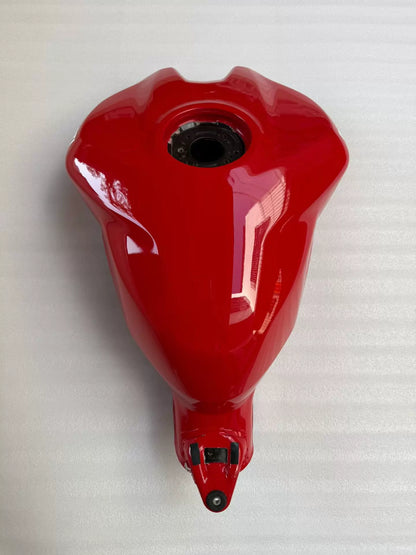 Red fuel tank for Ducati Panigale V2, front three-quarter view showing smooth glossy finish and mounting points