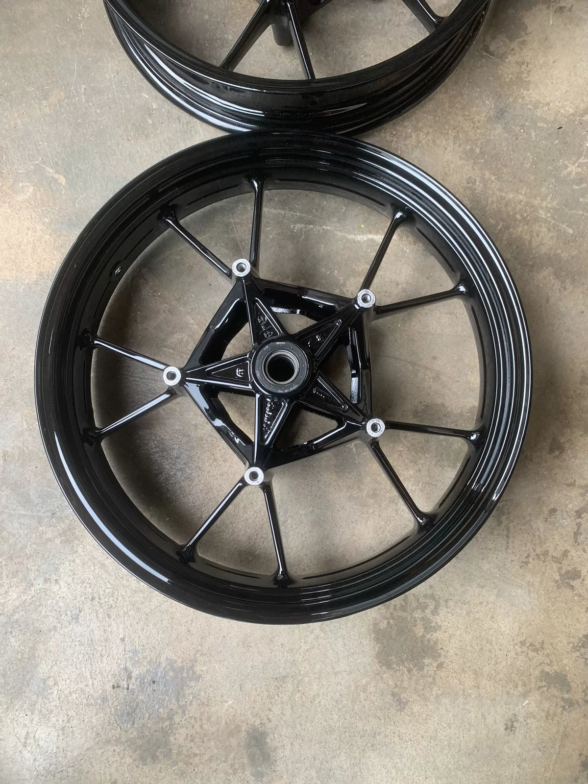 BMW S1000RR wheel set rear wheel side profile view, silver alloy rim and hub assembly