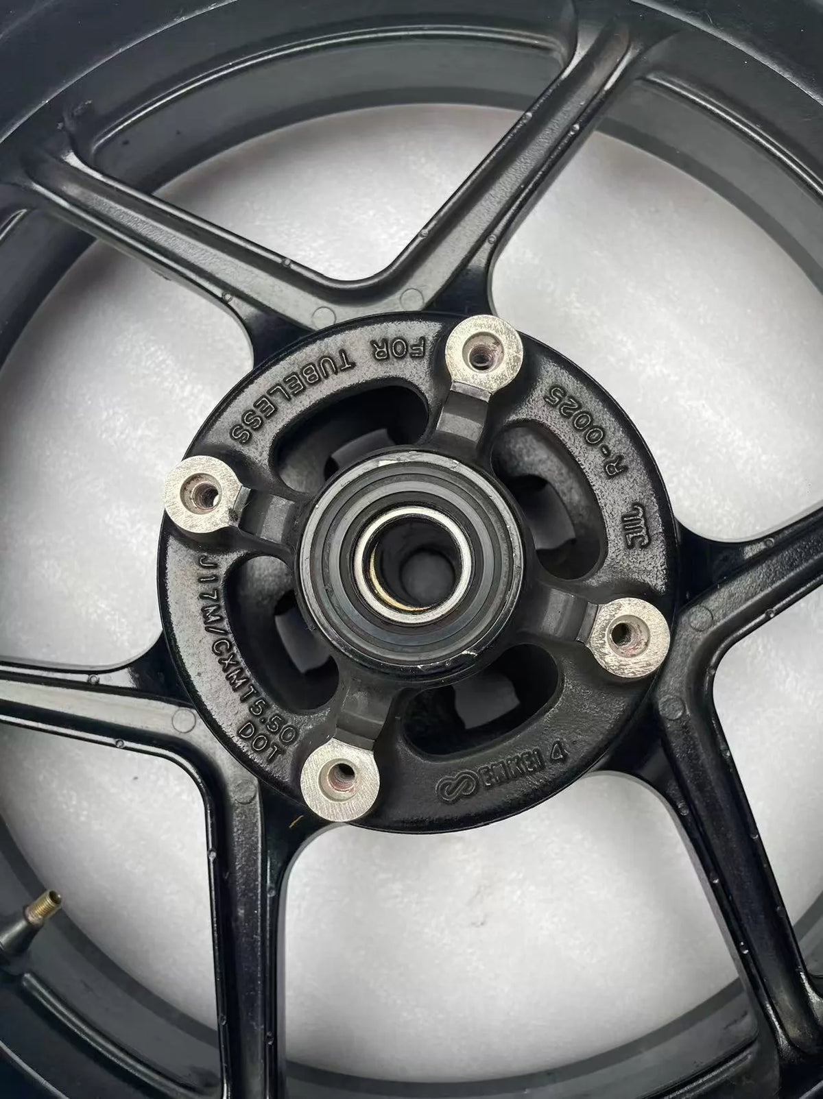 Kawasaki ZX-6R rear wheel rim WHEEL-ASSY gloss black, close-up of spoke and rim edge finish detail