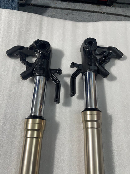 Top view of Kawasaki Z1000 fork uppers, black cast axle brackets and brake caliper mounts, polished chrome stanchions
