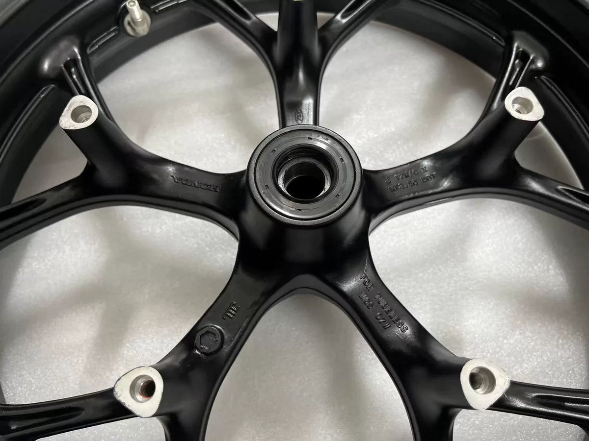 Honda NC750X front rim close-up, spoke detail and hub center visible, silver alloy construction