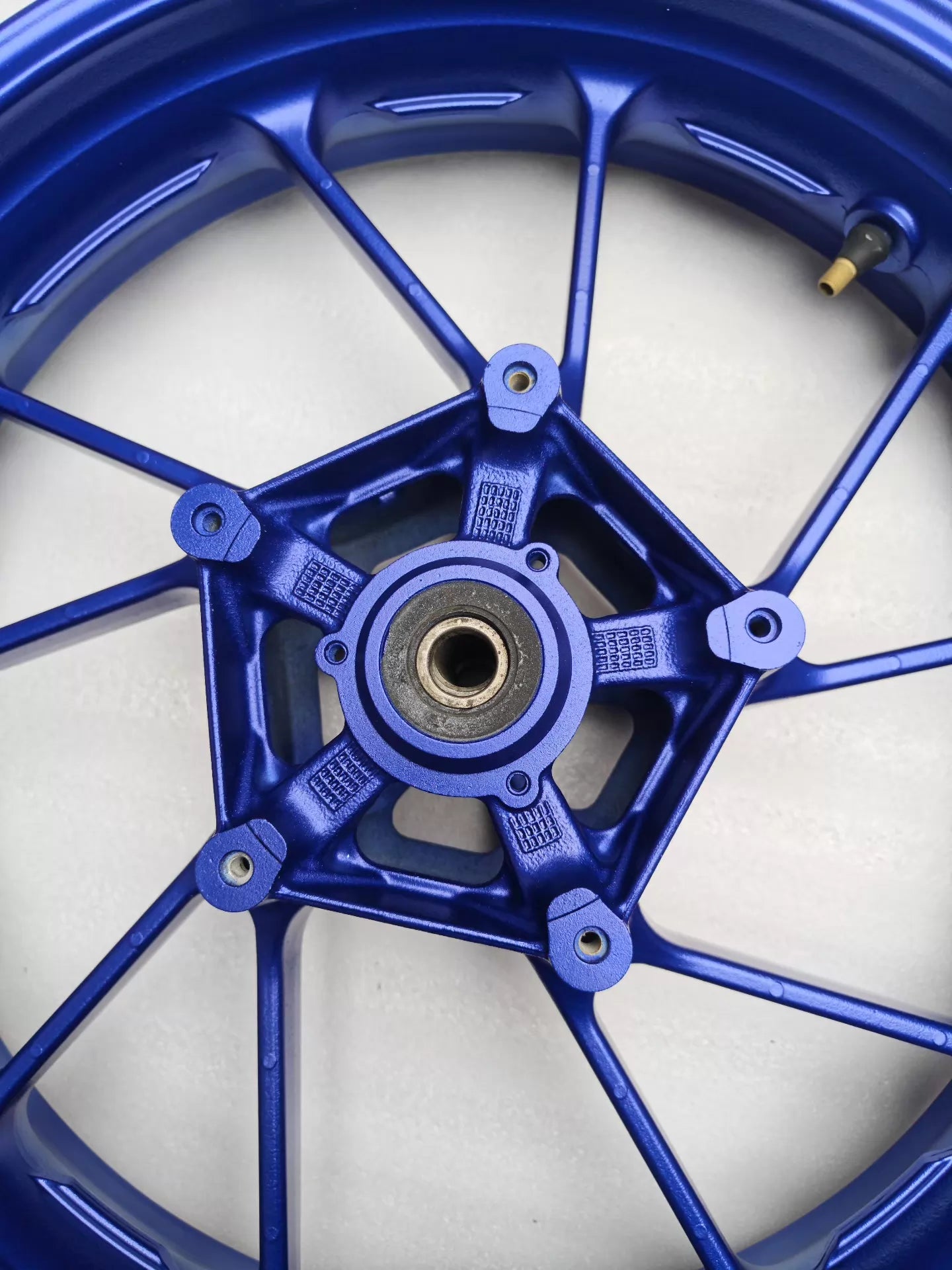 Rear hub view of blue cast front wheel for Yamaha MT-07 FZ-07 showing 5-spoke bearing bore and disc mount holes