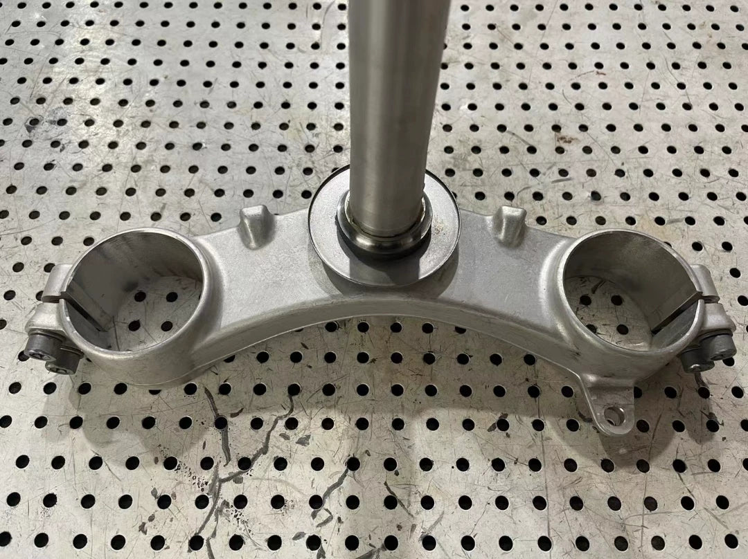 BMW S1000RR triple clamp top-down angle displaying machined aluminum upper clamp and mounting holes