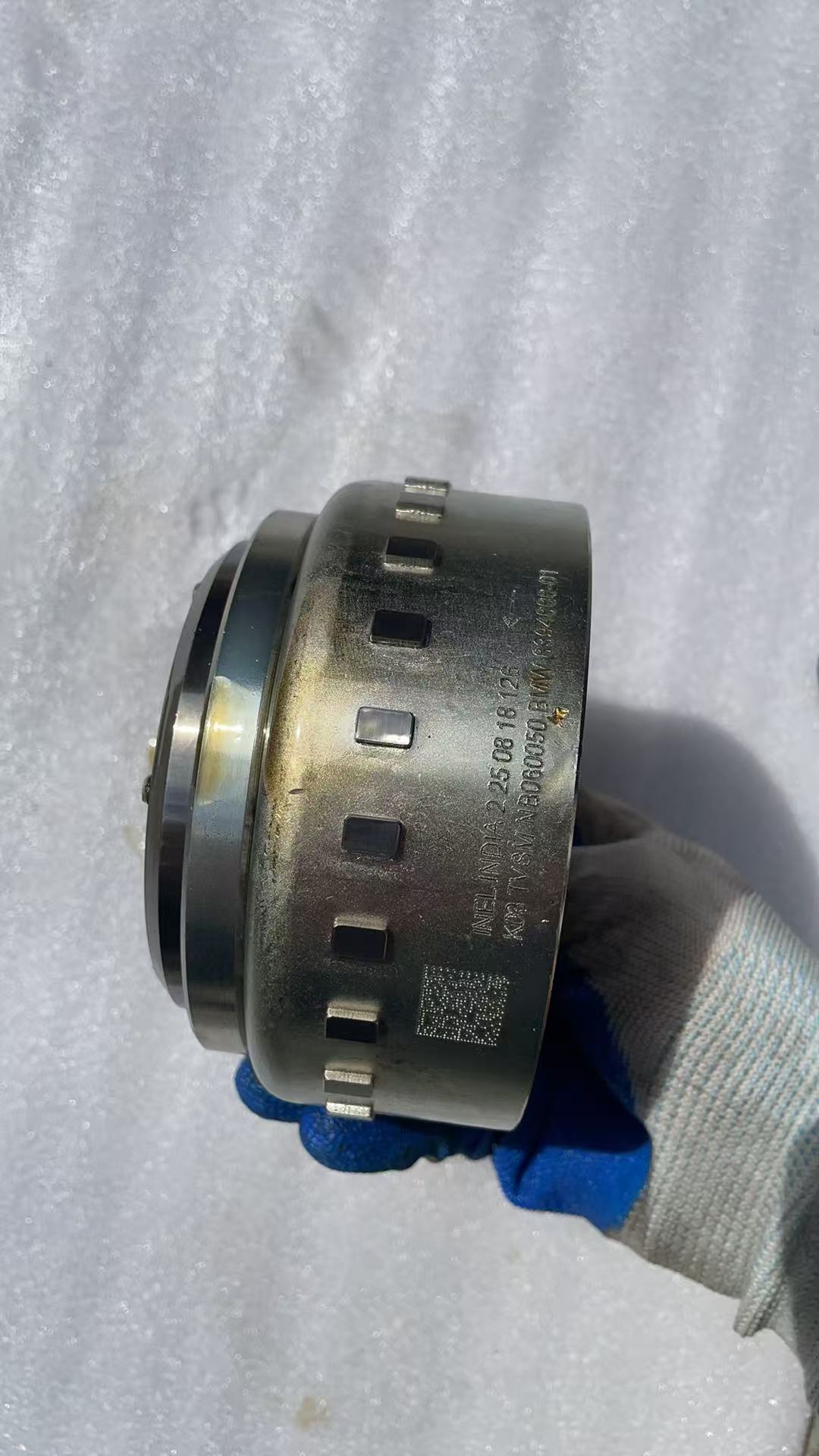 BMW G310R flywheel rear face with bolt holes and machined surface visible