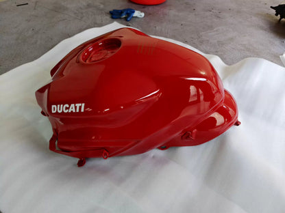 Red fuel tank for Ducati SuperSport 939, rear angle view displaying mounting points and contoured shape