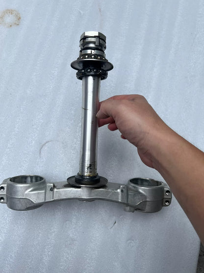 BMW S1000RR triple clamp top-down view displaying machined aluminum upper clamp with bolt holes