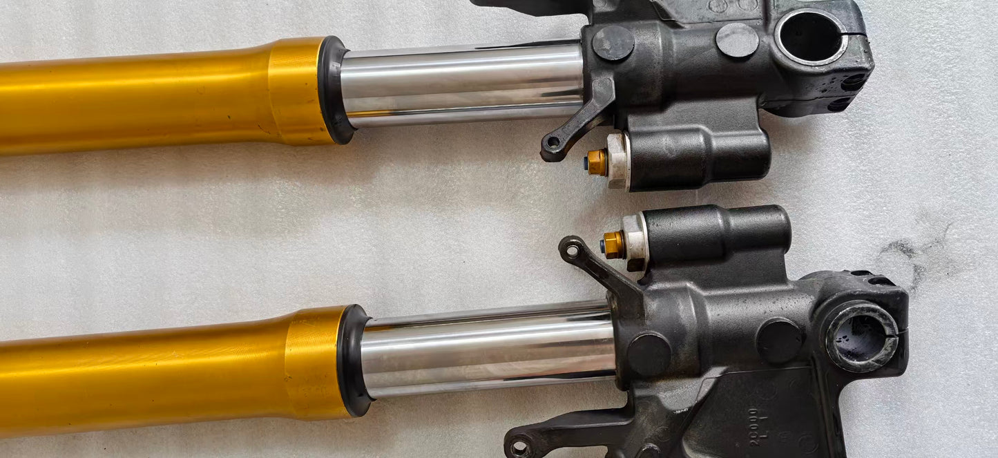 Close-up of YZF-R6 fork sliders, chrome tubes, gold uppers and black brackets with gold preload adjusters