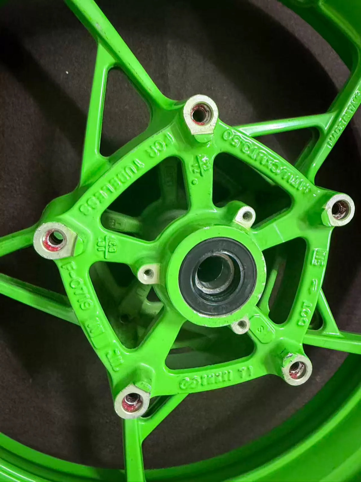 Anniversary edition green front wheel Kawasaki ZX-4RR, close-up of hub and brake rotor mounting area