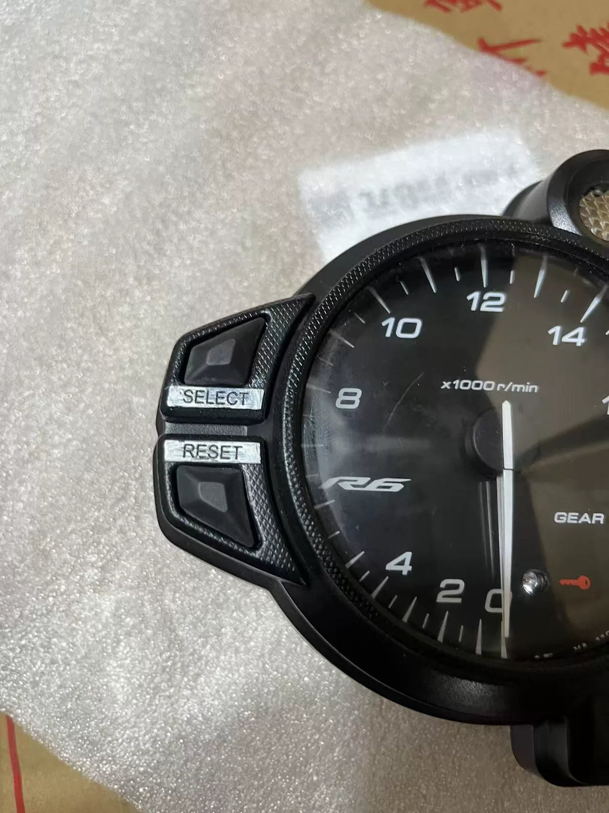 Yamaha YZF-R6 instrument cluster close-up of tachometer face and needle, clear markings visible