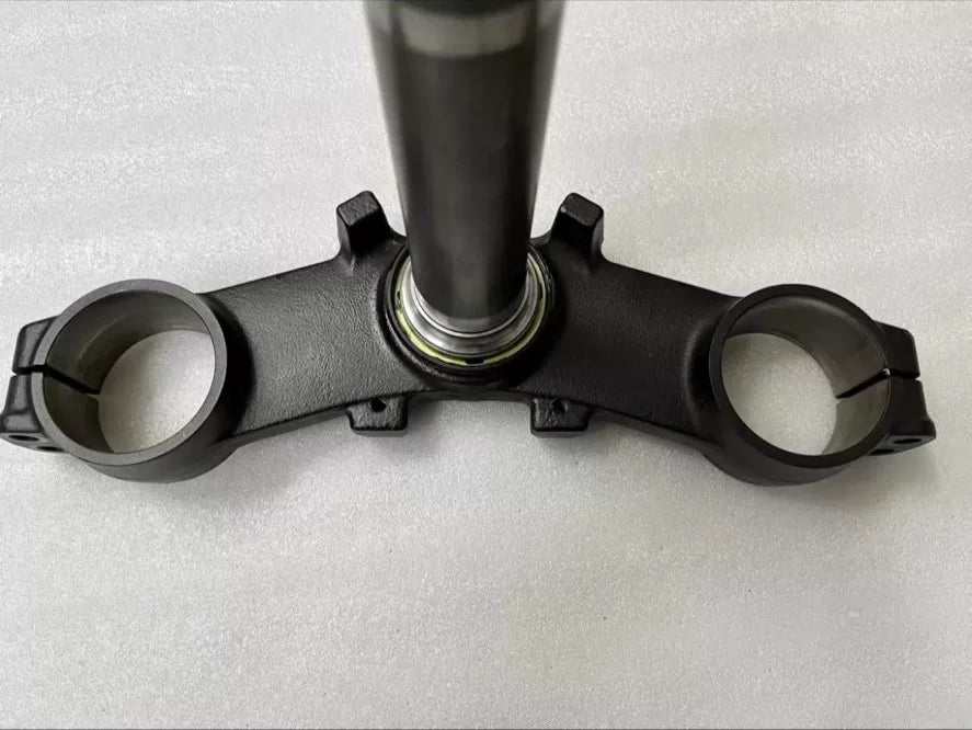 Kawasaki Z900 triple clamp close-up of fork tube clamp holes and bolt hardware, anodized aluminum surface detail