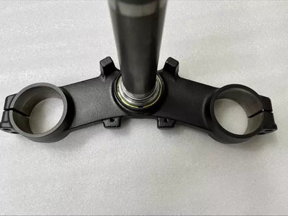 Kawasaki Z900 triple clamp close-up of fork tube clamp holes and bolt hardware, anodized aluminum surface detail