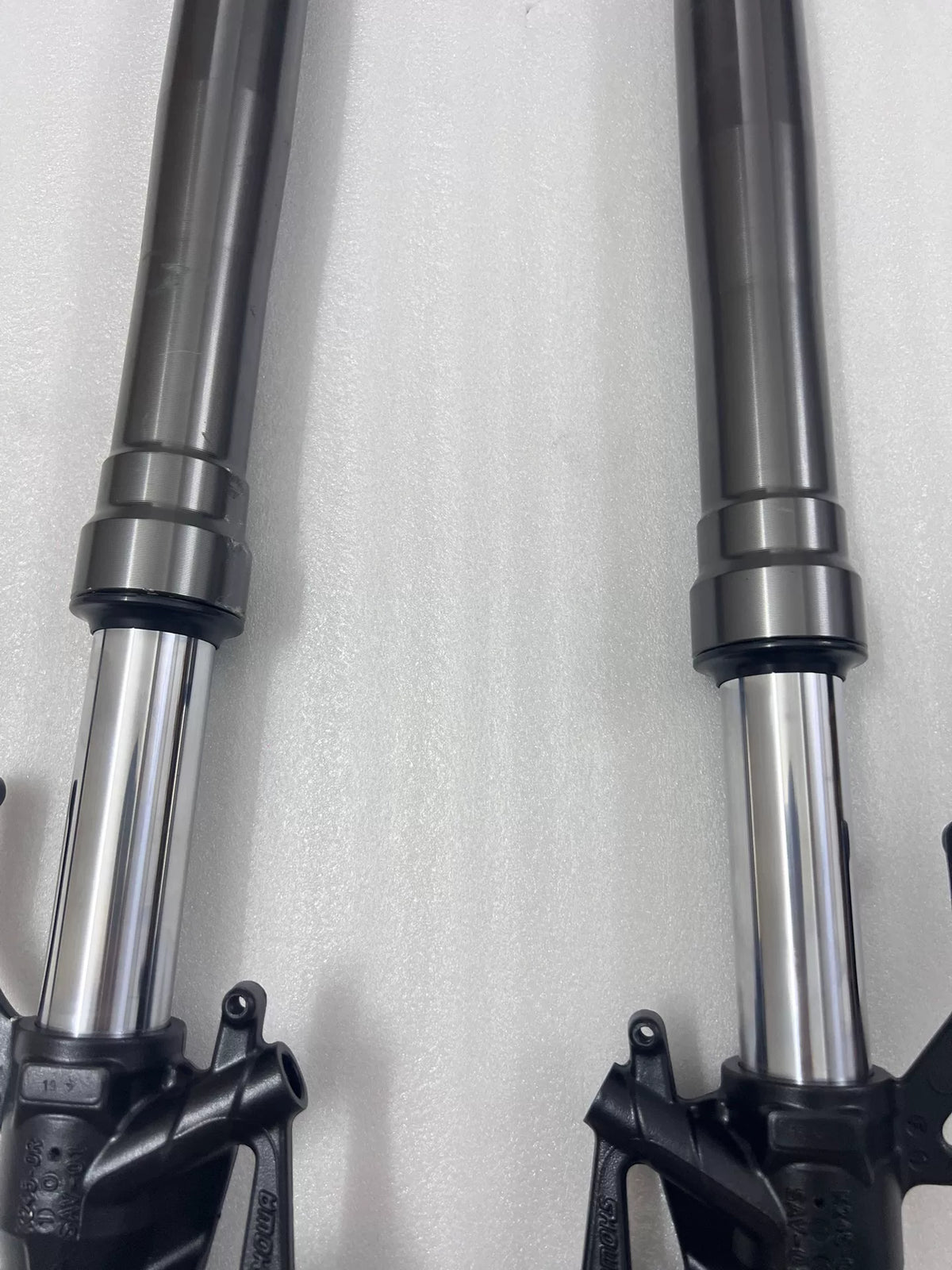 Kawasaki Ninja 1000 SX fork leg bottom close-up, axle clamp bolts and lower casting detail visible