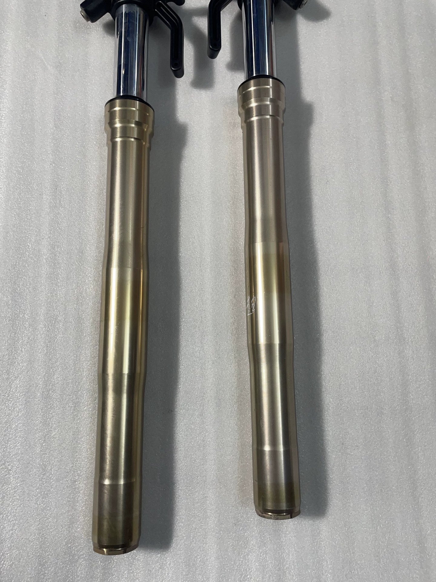 Kawasaki Z1000 front fork gold sliders close-up, chrome stanchions and blue tube caps visible at top