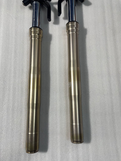 Kawasaki Z1000 front fork gold sliders close-up, chrome stanchions and blue tube caps visible at top