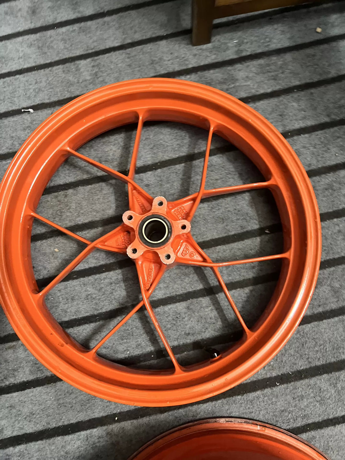 Close-up of orange wheel hub and axle assembly for KTM 790 Duke electric wheel