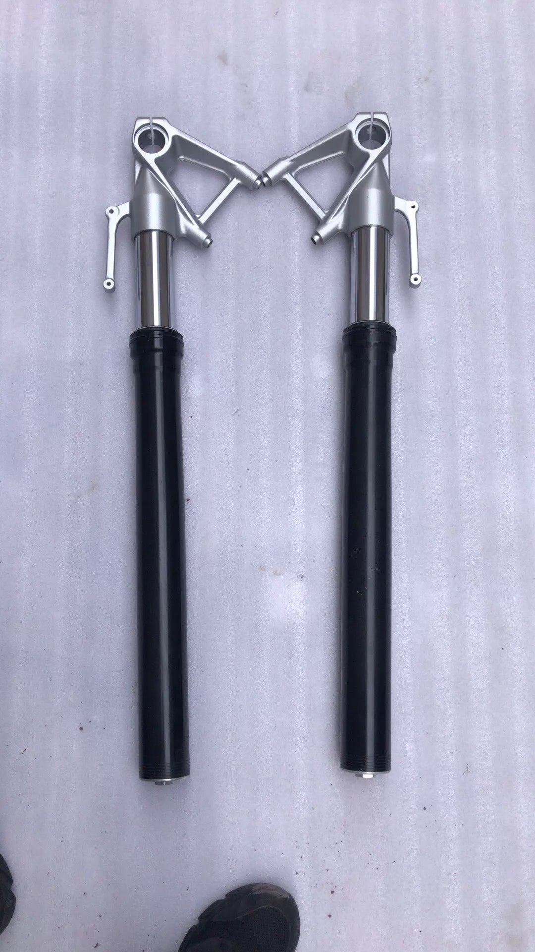 BMW S1000R fork leg left close-up showing brake caliper mount and axle pinch bolt bosses
