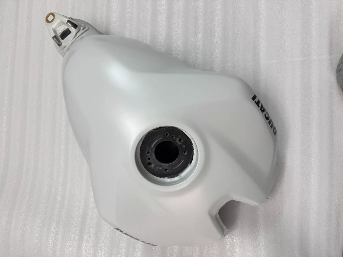 White fuel tank for Ducati Panigale V2, underside view exposing mounting brackets and fuel inlet port