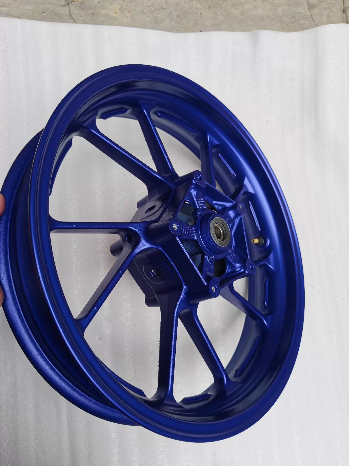 Three-quarter side view of blue cast front wheel for Yamaha MT-07 FZ-07, showing rim depth and spoke faces
