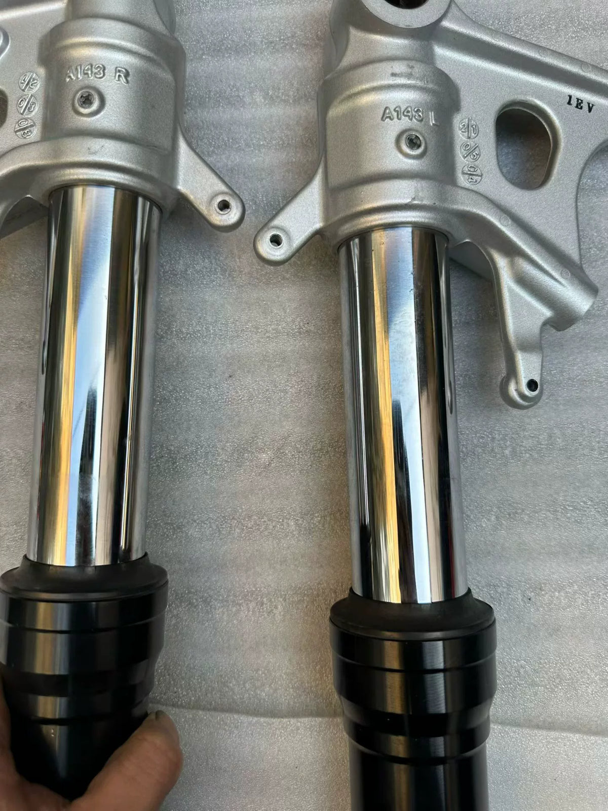 Aprilia Tuono 660 front fork rod single shaft close-up, smooth straight body, chrome finish detail