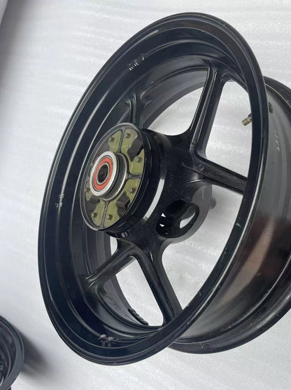 Kawasaki ZX-6R rear wheel rim WHEEL-ASSY gloss black, angled view displaying rim width and spoke pattern