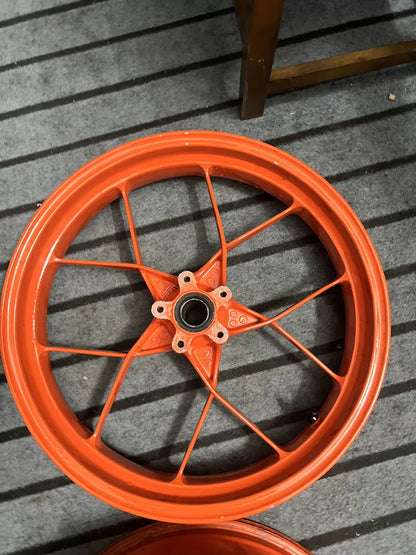 Orange KTM 790 Duke complete wheel set, angled view showing spoke pattern and finish