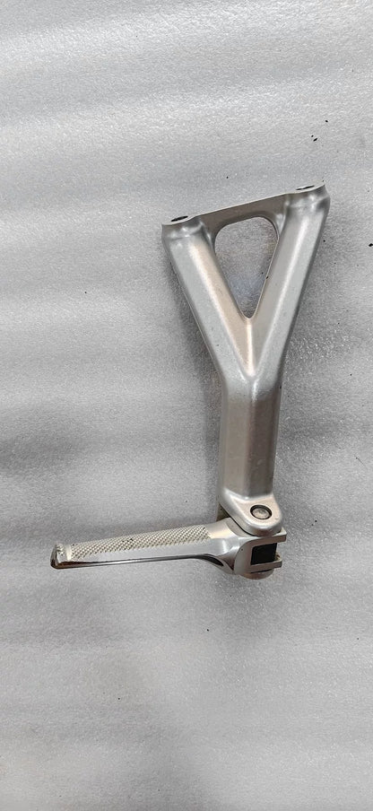 Ducati Panigale V4 footpeg bracket underside view revealing welded joints, bolt holes and raw aluminum finish