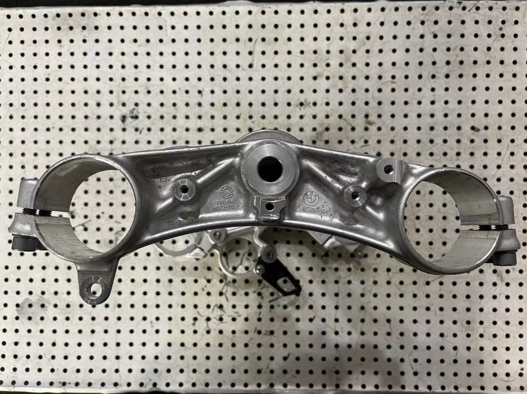 BMW S1000RR triple clamp angled view displaying complete assembly with lower clamp and fork spacing