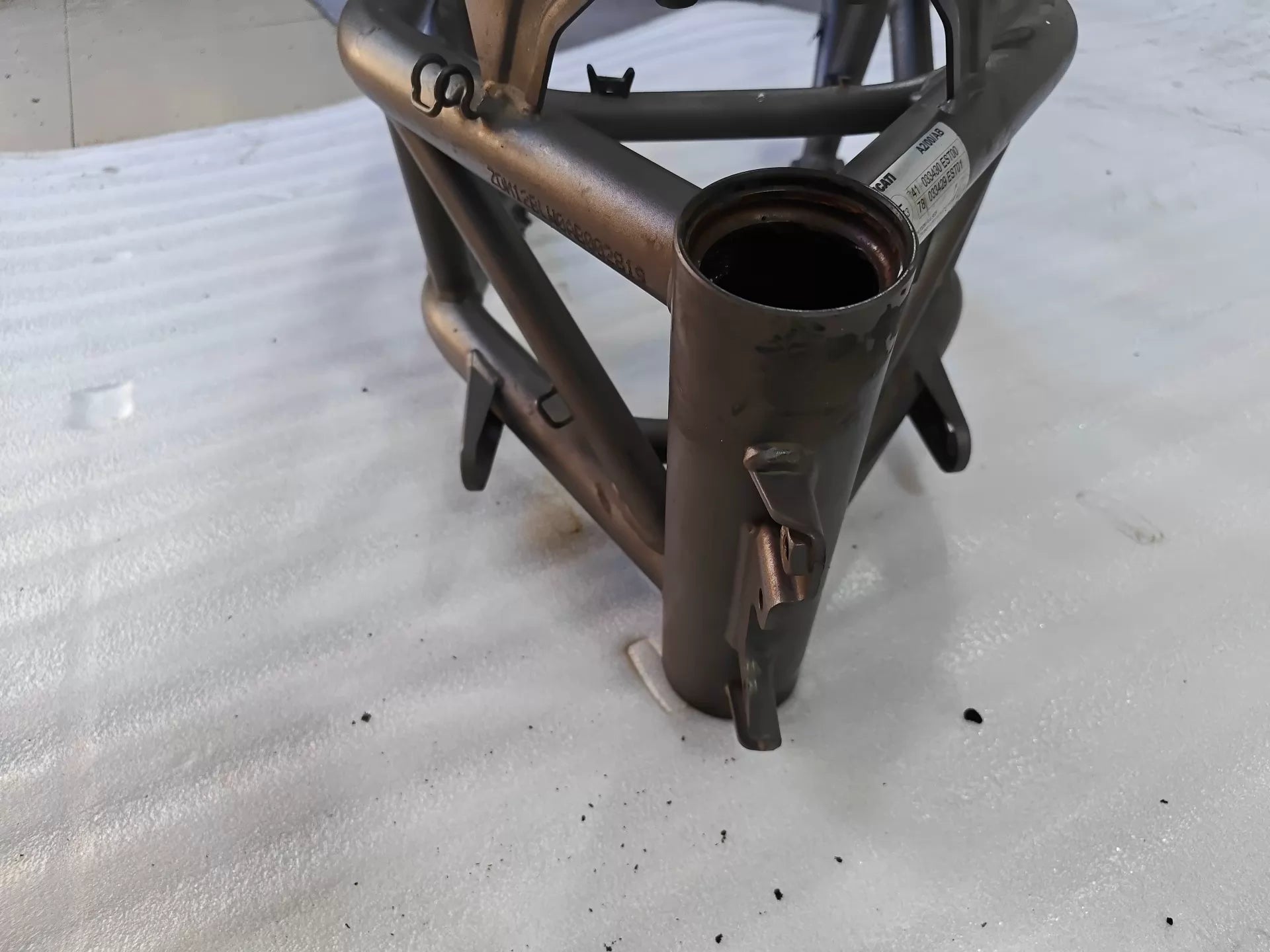 Close-up of grey trellis frame steering head tube and Ducati VIN label for Ducati MTS1200, used condition