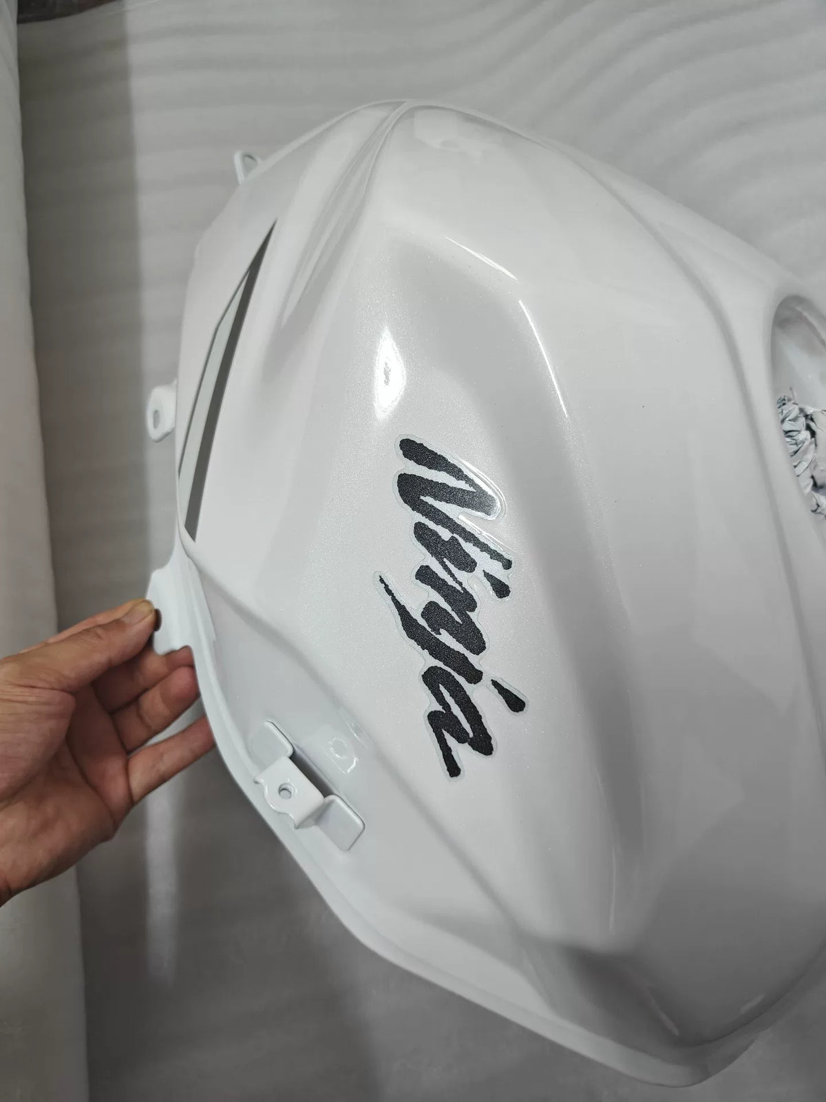 Kawasaki Ninja 400 white fuel tank underside view revealing mounting brackets and fuel pump port