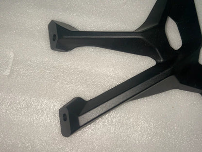 BMW S1000XR footpeg bracket, top-down view showing symmetrical bracket shape and surface finish