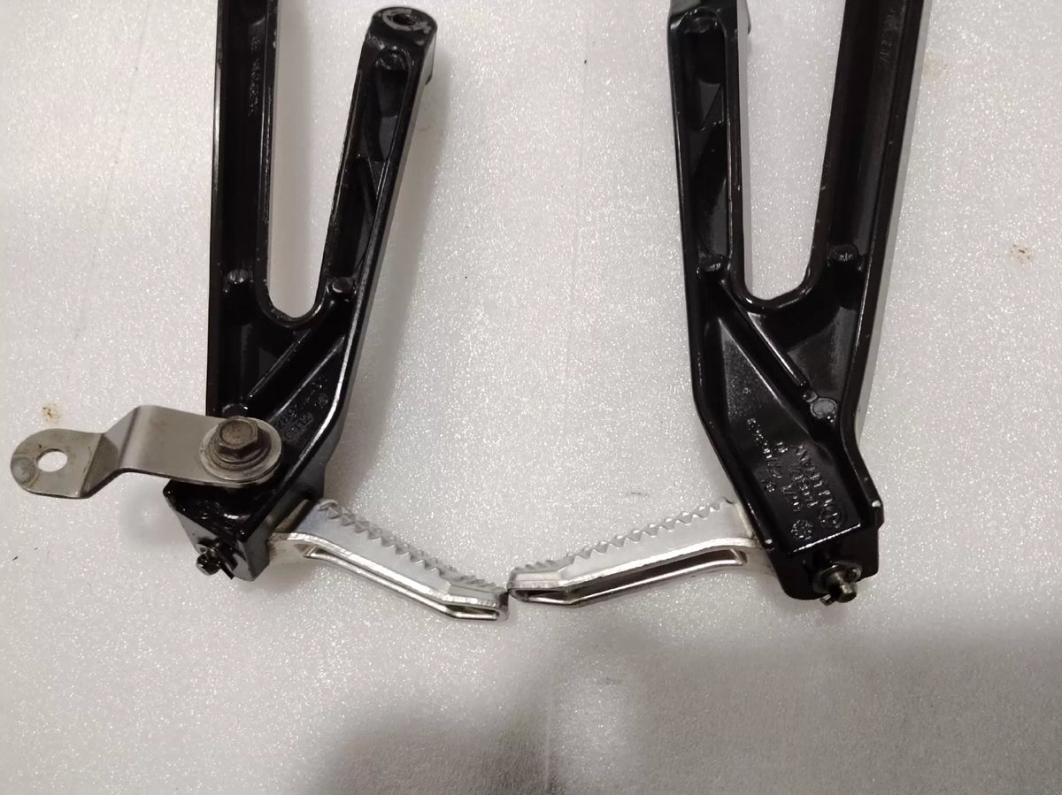 BMW S1000RR footpeg bracket, overhead flat lay view showing complete part dimensions and finish
