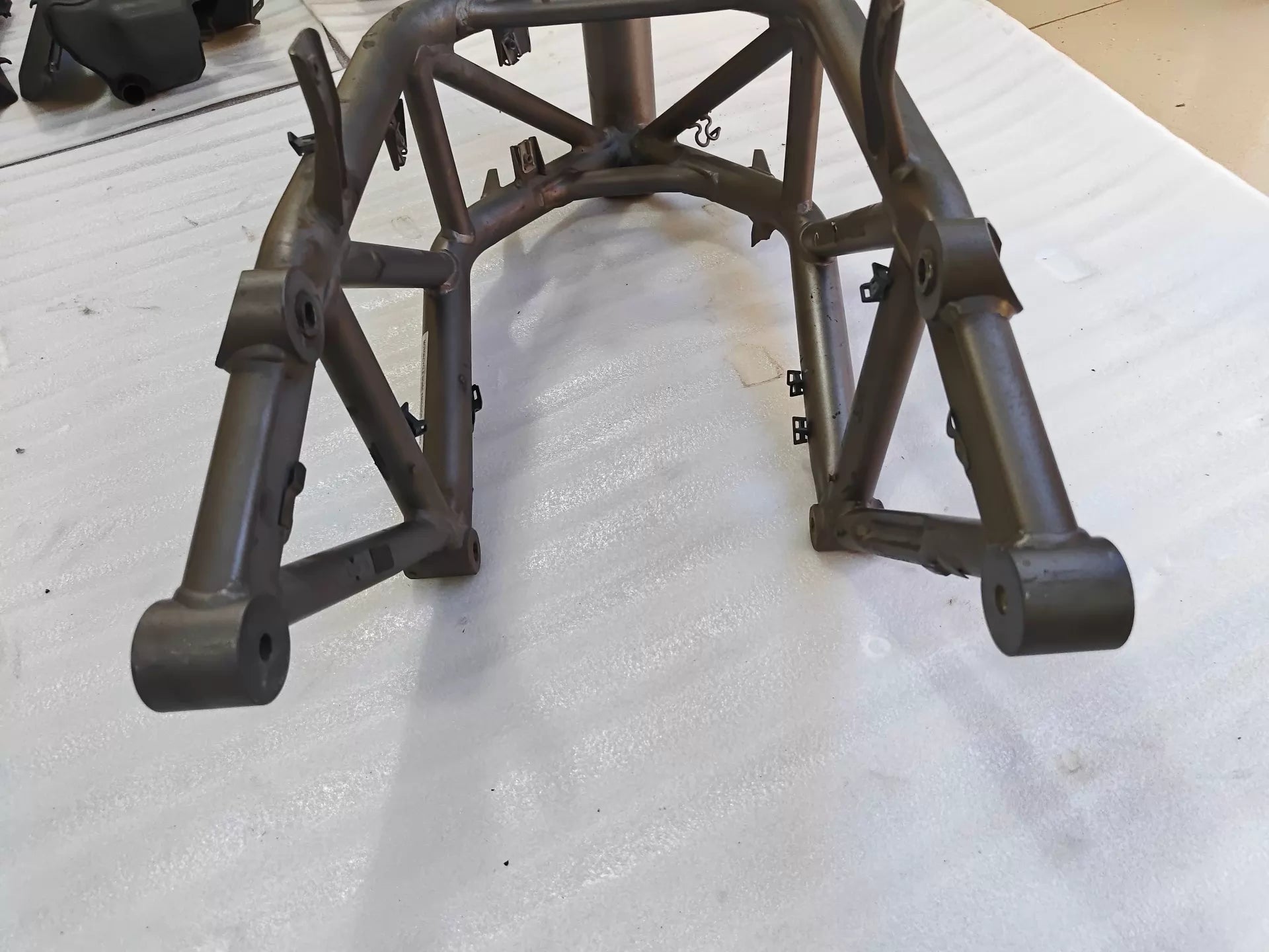 Low angle rear view of grey trellis frame for Ducati MTS1200, swingarm pivot bosses, welds visible, used