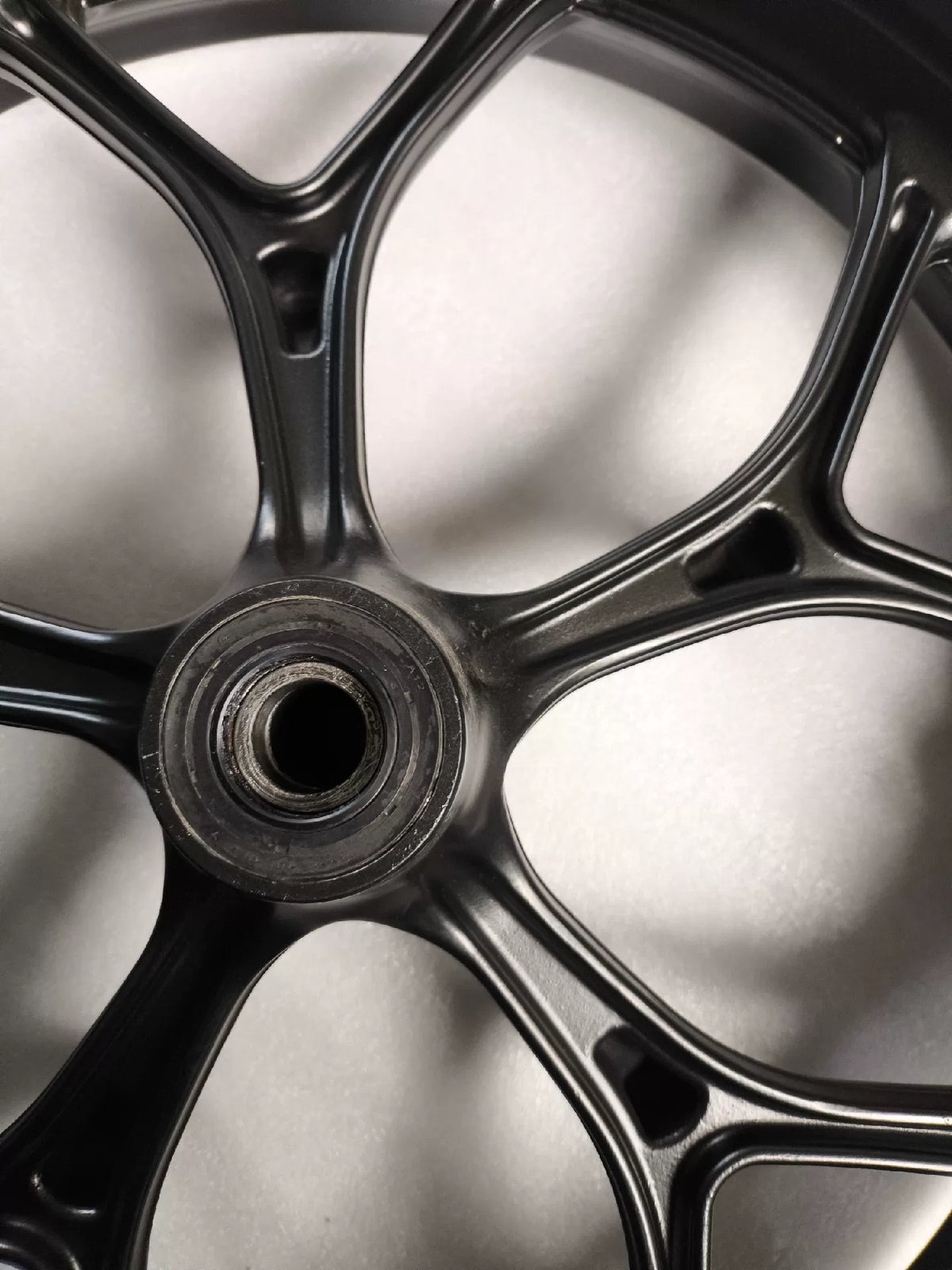 Black front wheel Honda NC750X close-up of hub center and axle mounting area