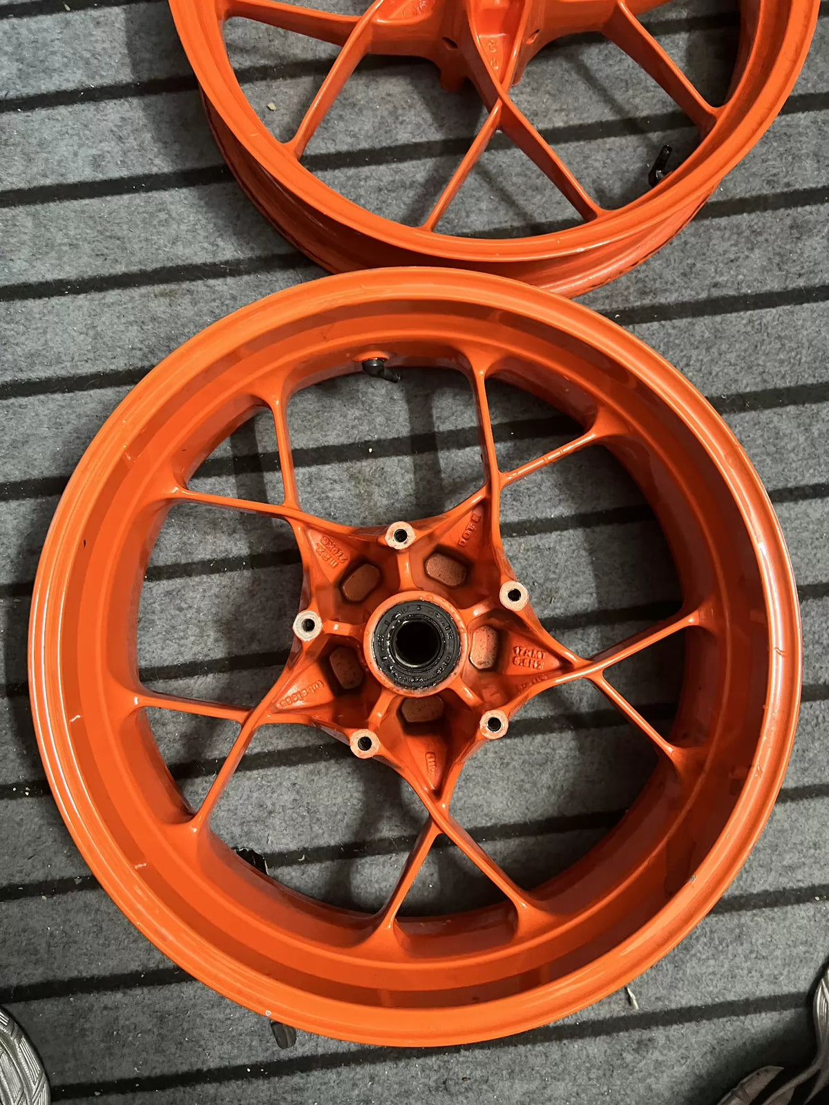 Orange KTM 790 Duke rear wheel, rear angle showing brake disc mount and spokes