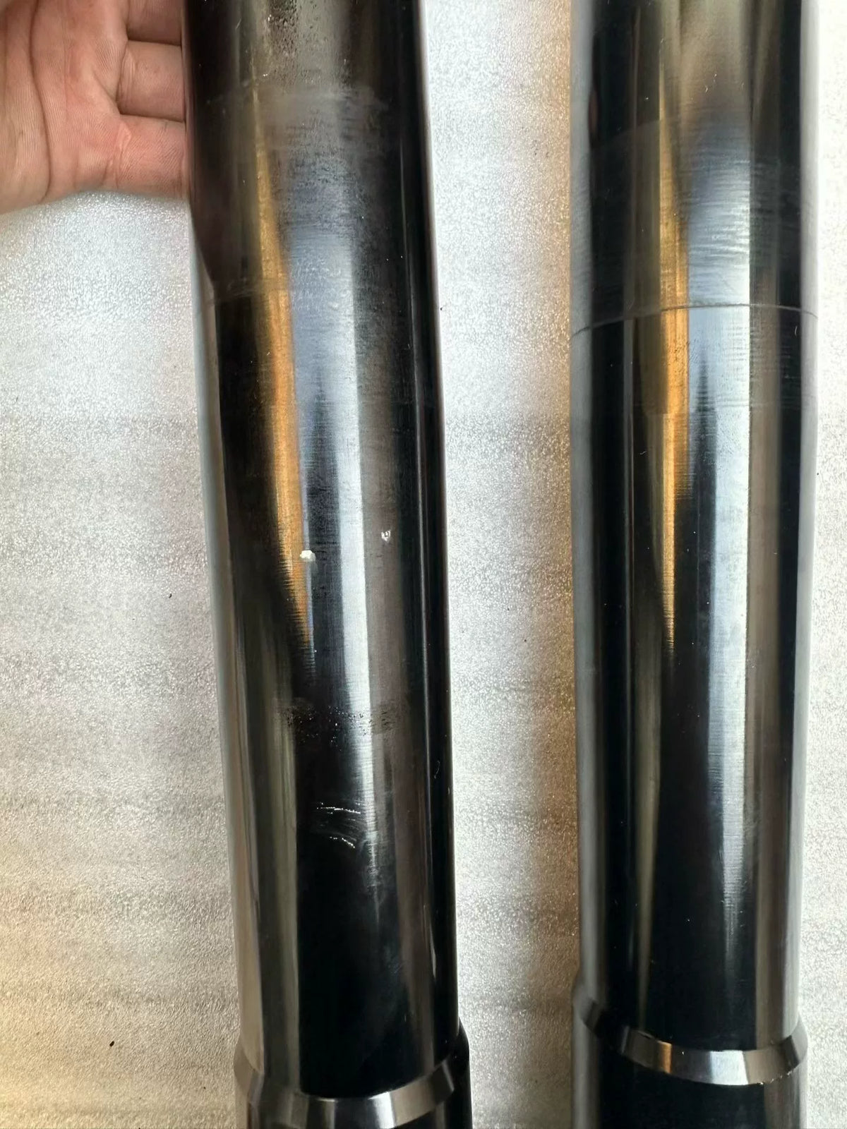 Aprilia Tuono 660 front fork rods pair upright view, polished straight steel shafts, top thread ends