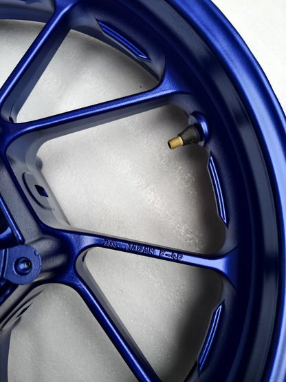 Close-up of gold valve stem and inner rim on blue cast wheel for Yamaha MT-07 FZ-07 with 'JAPAN F-4P' cast marking