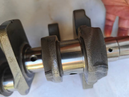 Front Yamaha MT-09 crankshaft view held in hand, tapered splined shaft end with seal and counterweight, polished journals
