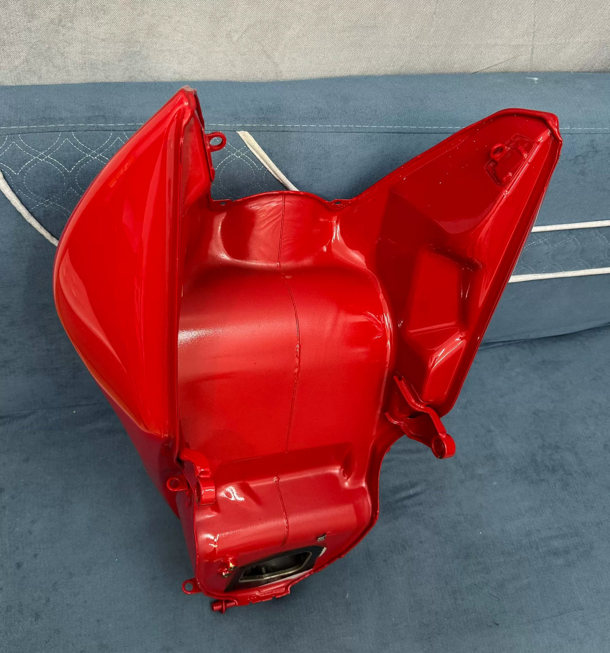 Gloss red fuel tank for Ducati Diavel V4, close-up detail of surface finish and panel curvature
