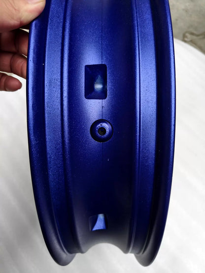 Rim bevel detail of blue cast wheel for Yamaha MT-07 FZ-07 showing valve hole, balance mark and paint texture