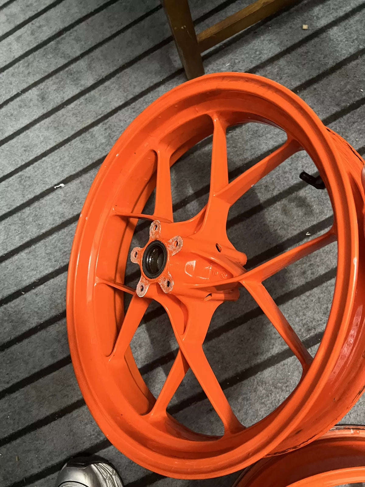 Orange KTM 790 Duke front wheel close-up showing bearing and axle detail