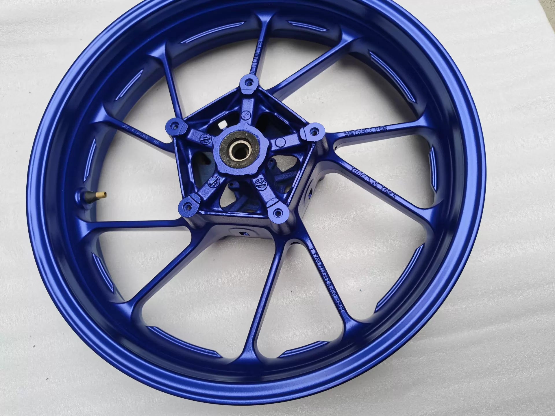Angled front view of blue cast wheel for Yamaha MT-07 FZ-07 showing hub, bearing and 'Suitable for Tubeless Tires' cast text